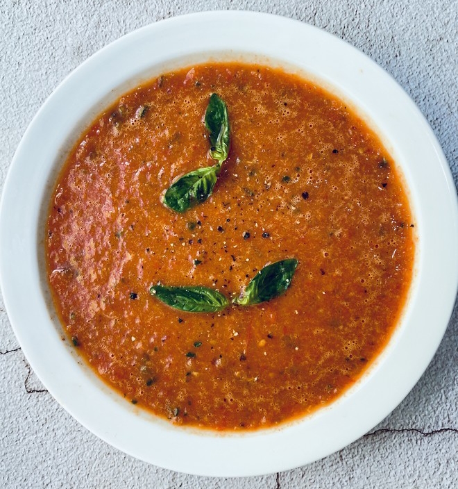 1 dish of bell pepper soup with 2 green Basil leaves 