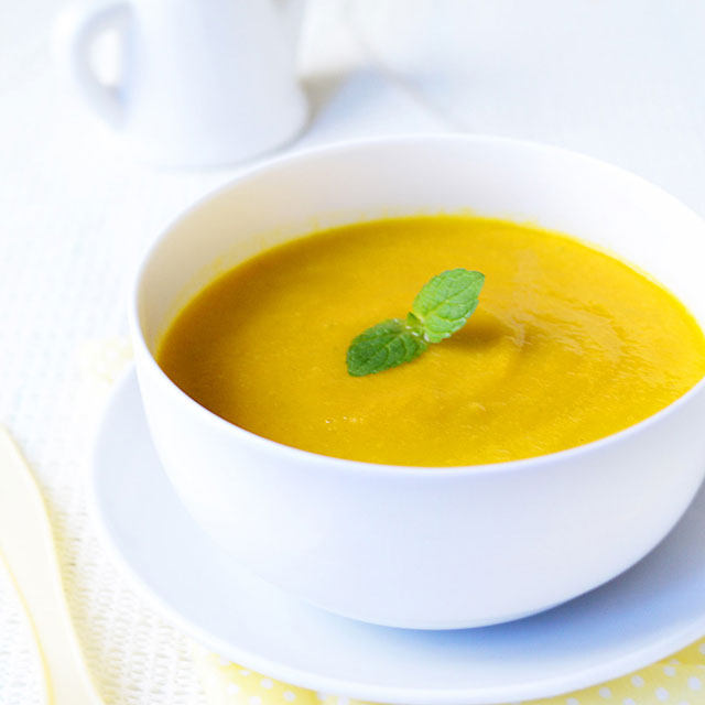 a bowl of carrot soup with yellow color