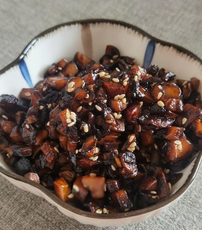 brown Shiitake Mushroom Sauce in a bowl with some white sesame seeds