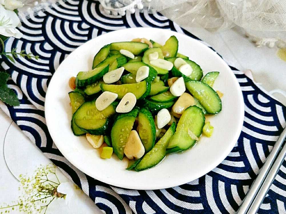  Stir fried Cucumber with some garlic slices in a white plate 