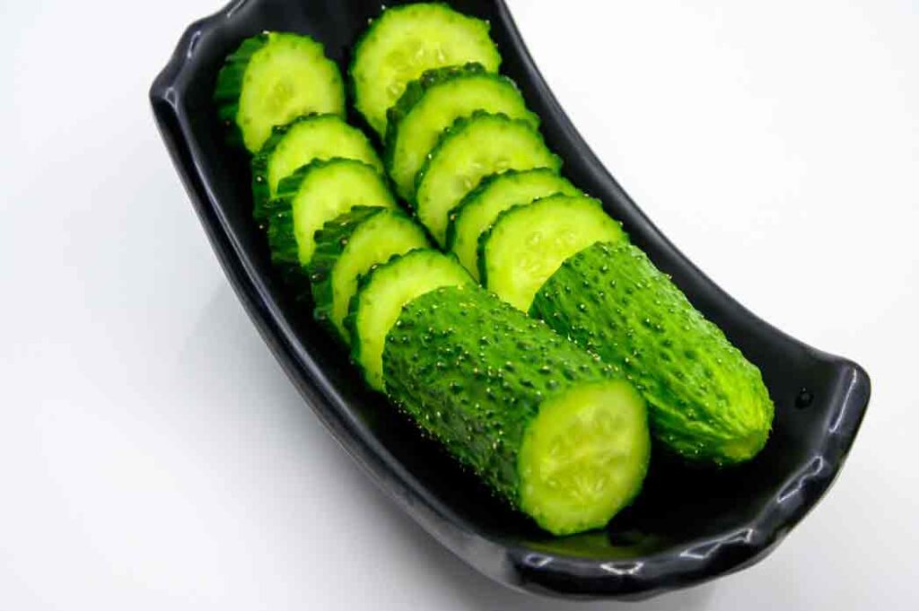 some cucumber pieces line in a long black bowl