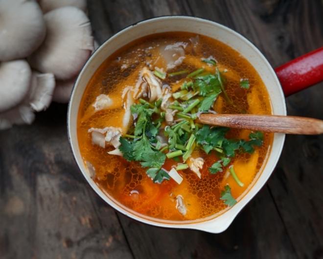 oyster mushroom soup in a pot with a spoon