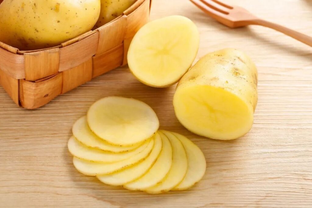 potato in a basket and some potato slices on table