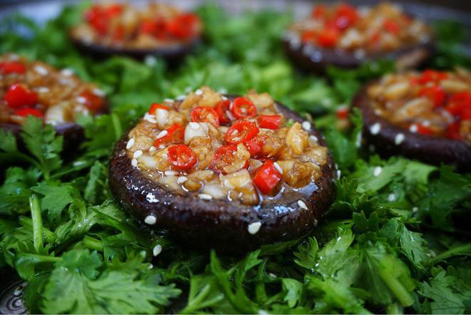 5 shiitake mushroom with a lot chopped garlic and red pepper on chopped cilantro