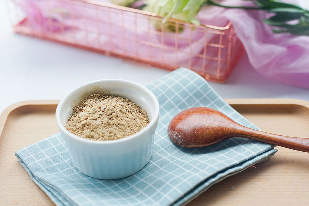 a little bowl of shiitake mushroom powder with a wood spoon