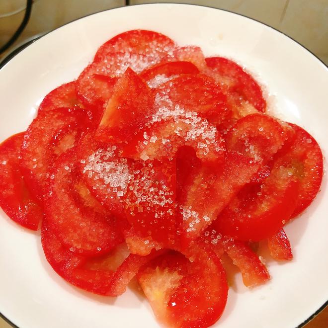 some tomato pieses on a white plate with some with sugar