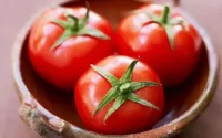 3 tomatoes in a brown bowl